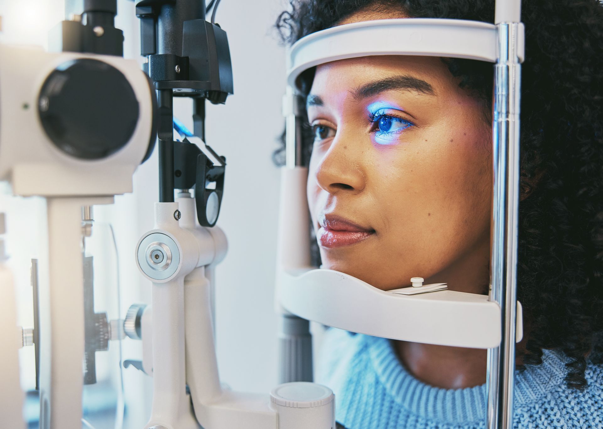 A woman undergoing health fund eye test with advanced ophthalmic equipment at an optometrist clinic.